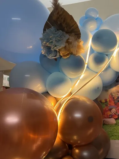 The little details matter, like the warm LED lights woven through this blue and bronze balloon garland, adding a magical glow.