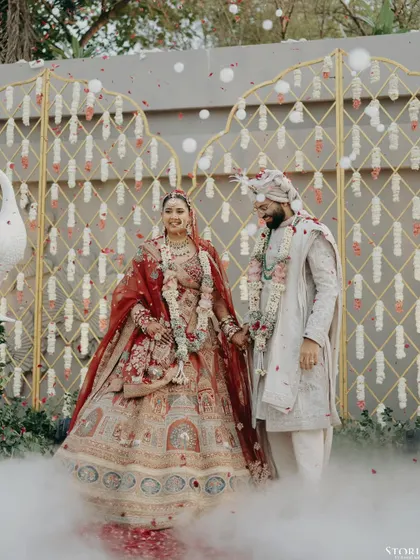 Kunal and Parul sharing a happy moment after their Varmala, surrounded by smoke effects that add a touch of magic.