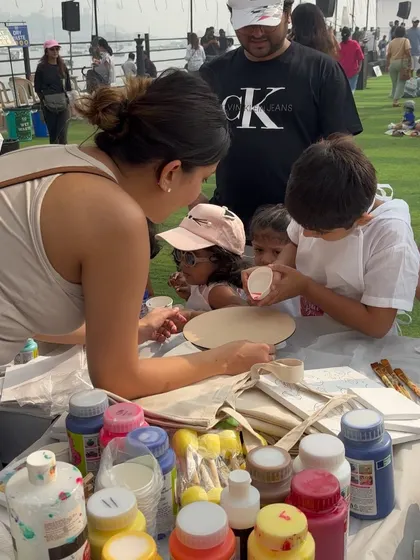 Me, at our art stall, showing a group of curious kids how to get started with their paintings. These sessions are all about hands-on fun.