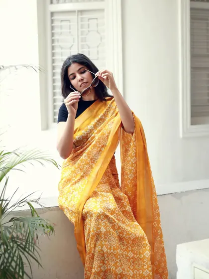 Using sunglasses as a prop, this shot adds a touch of modern style to a traditional saree look.