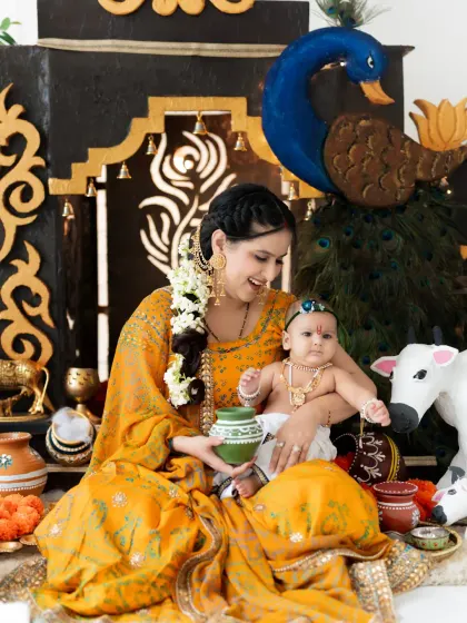 A playful moment between mother and child during our Janmashtami shoot. The authentic props and costumes help create a truly immersive experience.