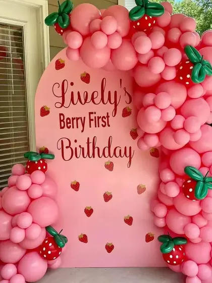 A sweet "Berry First Birthday" with a strawberry theme. I used a pink arched backdrop and a custom balloon garland with cute strawberry balloon accents.