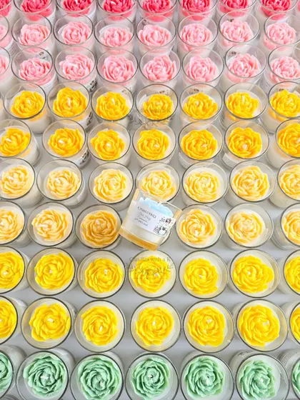 A closer look at the vibrant rainbow peony candles, showing the beautiful gradient of colors for the Holy Communion favors.