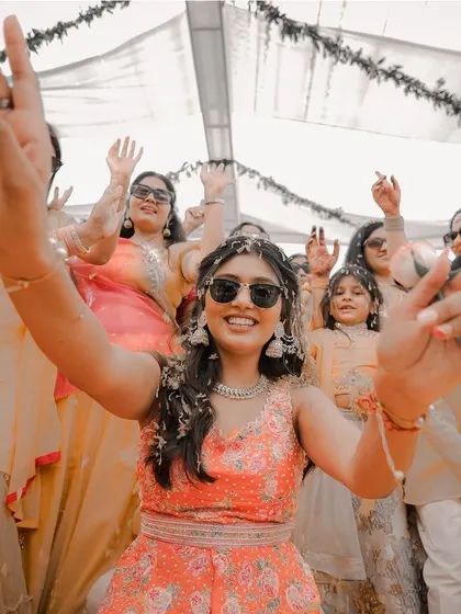 A shot that perfectly captures the bride's infectious energy during her Haldi ceremony. Her joyful expression and dance moves show she is having the time of her life.