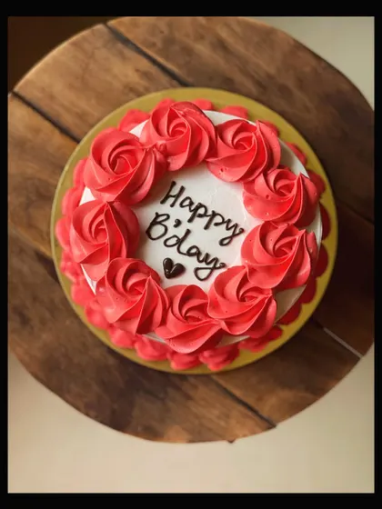 A top-down view of the classic birthday cake with red buttercream roses.