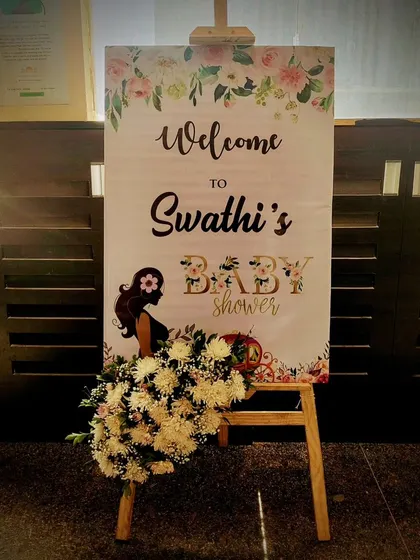 A welcome sign for a baby shower with a floral design.