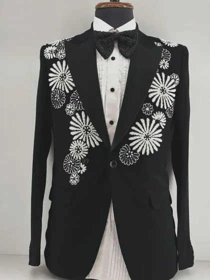 A black tuxedo with bold, graphic floral embroidery in white and black. This design offers a modern, high-contrast take on floral motifs.