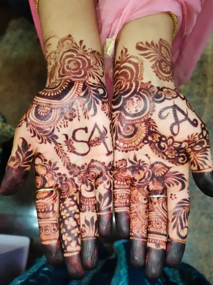 A close-up of a personalized design with the initials 'S' and 'A' beautifully incorporated into the intricate patterns on the palms.