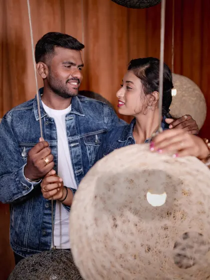 A cozy moment between a couple, framed by the unique texture of our hanging lamps.