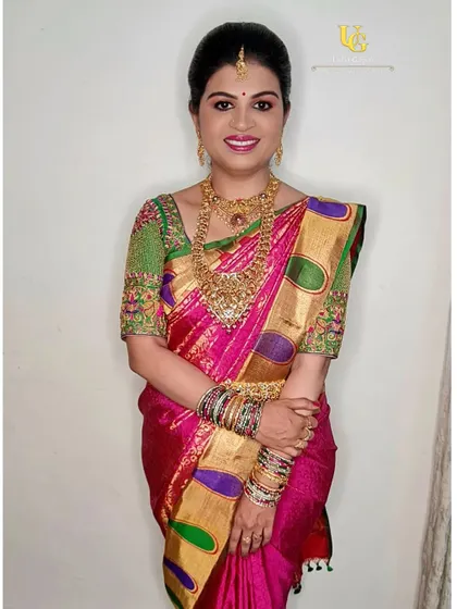 A full-length photo of Preethi, looking stunning in her pink and green Kanjeevaram saree for the naming ceremony.