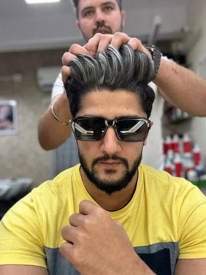 Men's fashion starts with great hair. This silver color on a high-volume pompadour is a statement look that is both sharp and stylish.