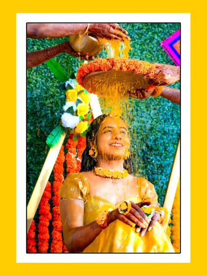 Another joyful shot of the bride enjoying the Haldi shower ritual.