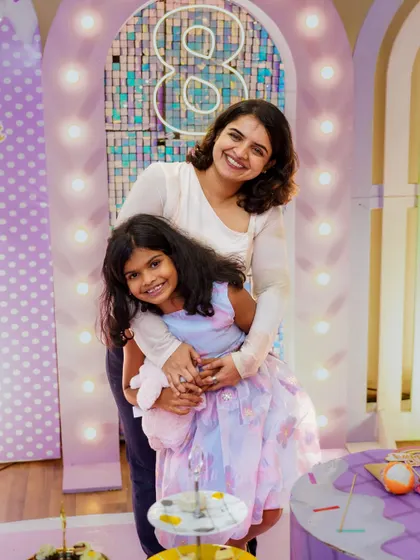 A loving hug between a mother and her daughter at an 8th birthday party. We focus on capturing the warm connections between family members during celebrations.