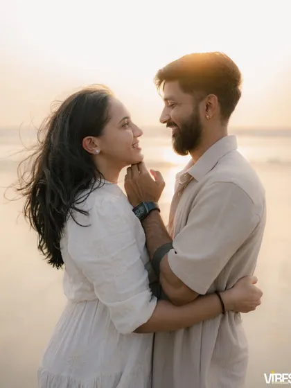 A beautiful, candid shot of a couple looking at each other with love and affection on the beach. The natural light of the sunset creates a soft, dreamy glow, ideal for romantic couple photography.