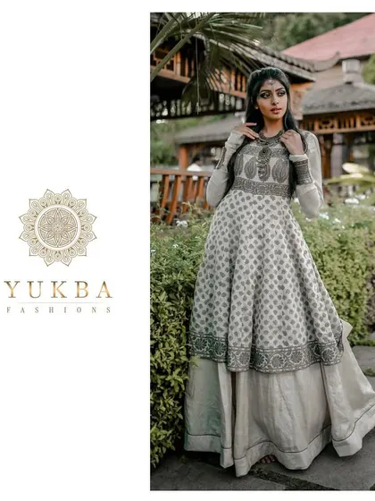A model showcasing a layered Anarkali gown with block-printed details. The design combines a flowing printed skirt with a structured, embroidered bodice for a unique Indo-Western feel.