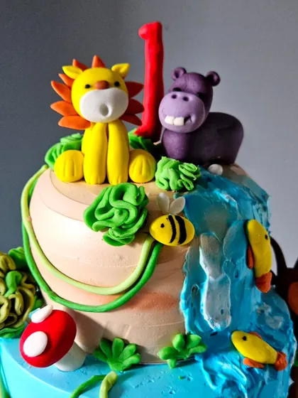 A detail shot of the top of the jungle safari cake, featuring a lion and hippo by a cascading waterfall.