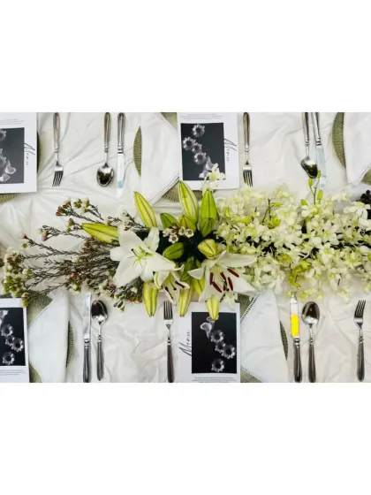 A beautiful centerpiece of white lilies and orchids from the plum and grape themed dinner.