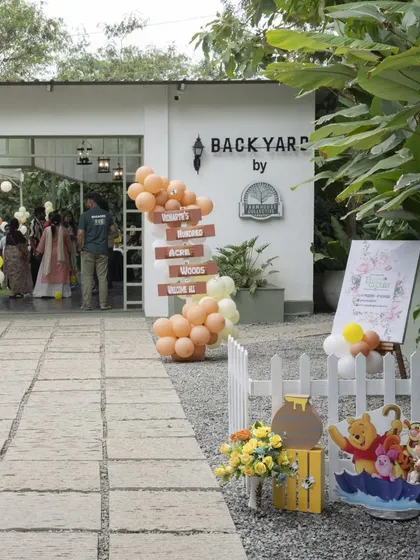 The entrance to the 'Winnie the Pooh' party at the 'Backyard' venue. A welcome sign and themed props greet guests as they arrive.