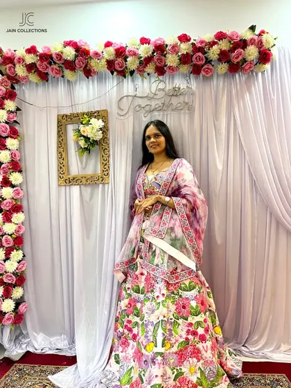 A happy client in a beautiful white floral lehenga. The bright, colorful embroidery makes it a perfect choice for a Mehendi or a spring wedding.