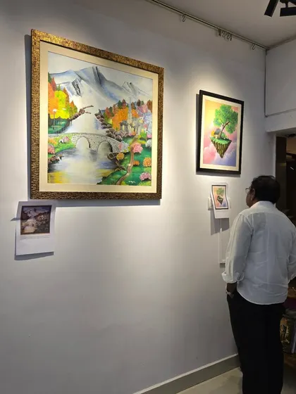 A visitor admires a large landscape painting at the "Timeless Whispers" exhibition. Our gallery provides a quiet space to connect with art on a personal level.