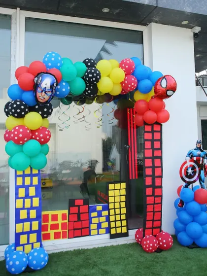 The entrance to a superhero party needs to make a statement! This balloon arch is designed to look like city buildings, with Captain America and Spider-Man ready to welcome the guests.