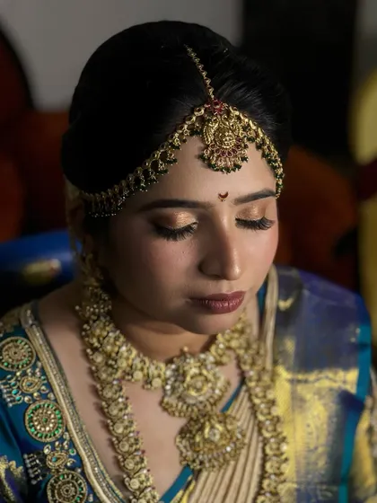 An eyes-closed shot to highlight the soft, golden eye makeup that complements her traditional attire.