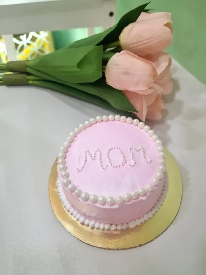 A simple and elegant cake to celebrate Mom. This pink-frosted bento cake is decorated with the word "MOM" in delicate pearls, making it a sweet and thoughtful gift for Mother's Day.