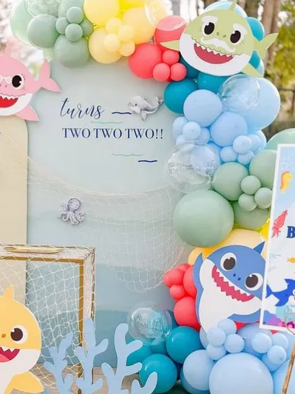 A closer look at the Baby Shark backdrop, with cute characters, a fishing net detail, and a vibrant balloon arch.