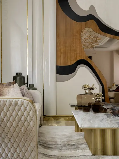A close-up on the details that define our style. A quilted velvet sofa, a fluted brass coffee table base, and a sculptural wall panel combining wood and lacquer create a rich tapestry of textures and forms.