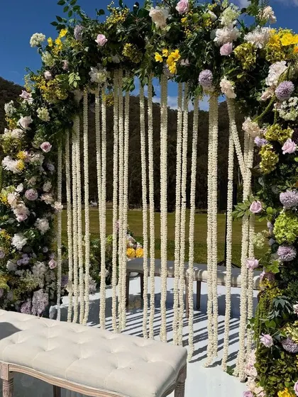 A close-up of a floral arch with hanging tuberose strings, perfect for a romantic and fragrant setting.
