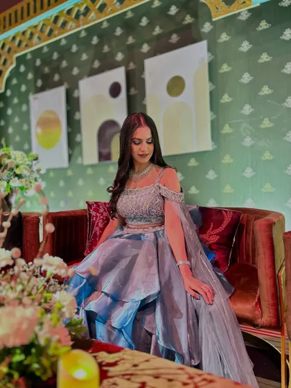 Seated on a plush red sofa, this shot highlights the contrast of colors and the beautiful texture of the gown.