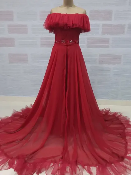 A complete look at the red off-shoulder maternity gown. Its A-line cut and flowing trail are designed to be both comfortable and visually stunning.