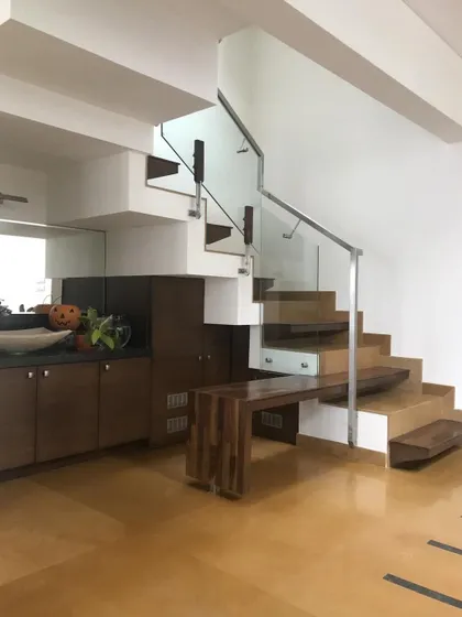 A custom-designed staircase in the 'Avaneesha' residence that incorporates a built-in bench and storage, showcasing our focus on smart, space-saving solutions.