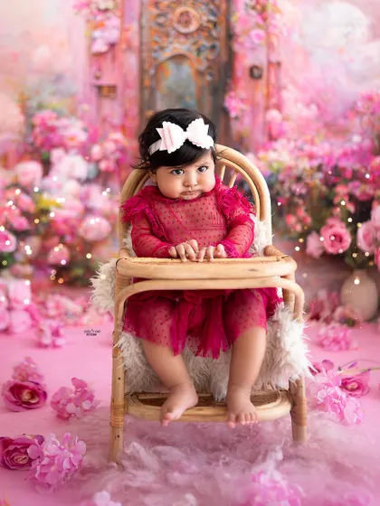 Sitting up tall in her high chair, this six-month-old is the queen of her pink floral kingdom.