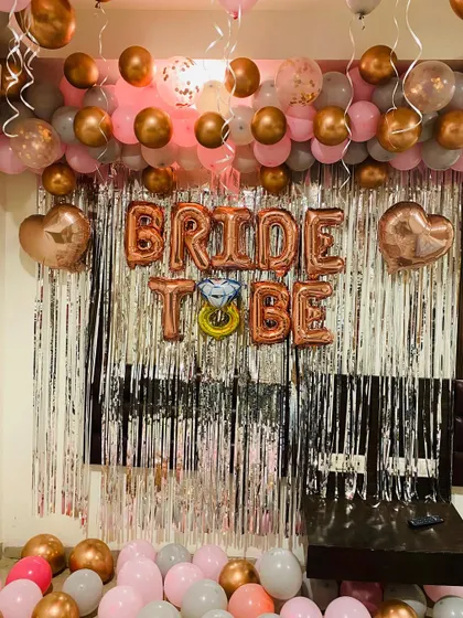 A chic and modern photo booth I designed for a bride-to-be party. This setup uses a popular color scheme of rose gold, pink, and grey balloons, with a shimmering silver fringe backdrop. The large 'BRIDE TO BE' foil balloons, complete with a diamond ring detail, make it a perfect spot for pictures.