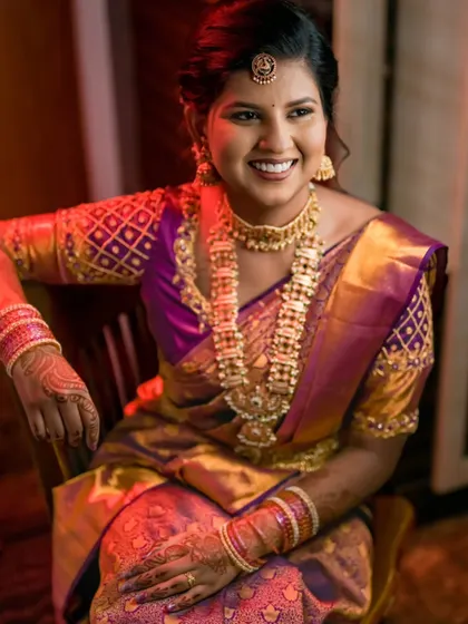 A radiant portrait of the bride-to-be, her smile lighting up the frame, showcasing her stunning purple and gold engagement saree.