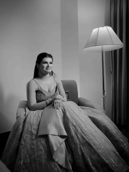 A beautiful black and white portrait of the bride-to-be seated, her gown spread around her. She looks happy and radiant on her engagement day.