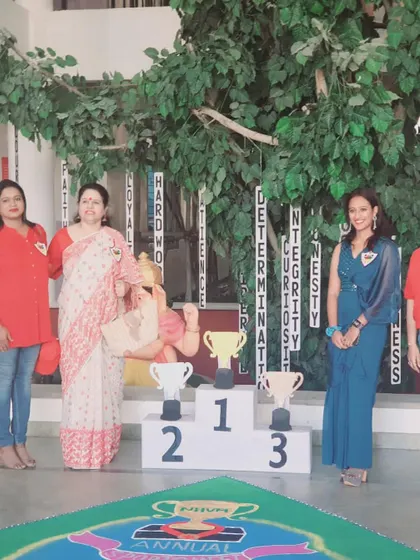 Standing by the winner's podium at my old school's sports meet. The words on the wall, like 'Hardwork' and 'Determination', are values I live by and teach at my academy.