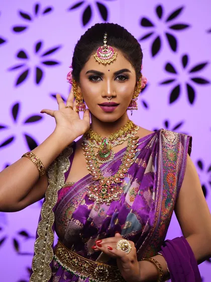 A graceful, dance-like pose. This shows how the makeup and styling work together to create a look that is not just beautiful but also expressive.