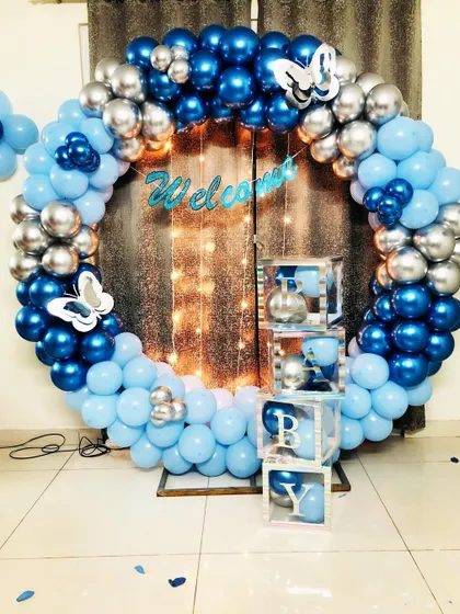 A closer look at the welcome party setup, featuring 'BOY' display boxes filled with matching balloons.