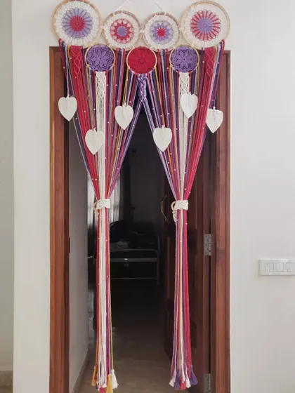 Our custom macrame dreamcatcher curtain tied back to create an elegant entrance. This piece is both a beautiful wall hanging and a functional door curtain.