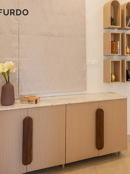 A stylish sideboard with fluted paneling and unique wooden handles. Paired with minimalist arched wall shelves, this unit provides both storage and a beautiful decorative element.