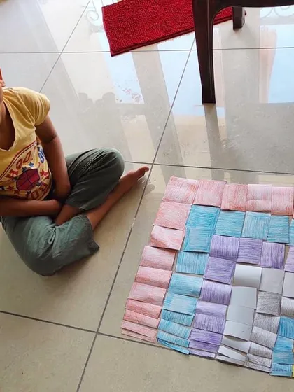 A child works on his homemade Decanomial Square. This activity, part of our distance learning program, shows how Montessori principles can be applied at home to teach color, size discrimination, and early math concepts.