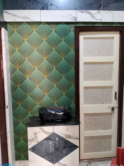 An art-deco style wallpaper with a green and gold fan pattern, installed in a bathroom.