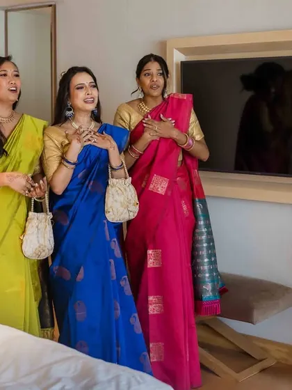 The bridesmaids look on as the bride stands fully ready, a beautiful moment of anticipation before she walks down the aisle.