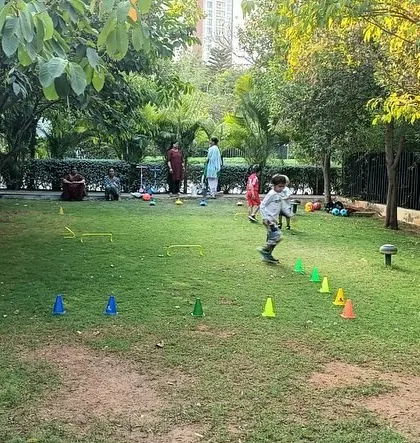 A young girl runs through a cone drill, showing the energy and fun of our outdoor classes.
