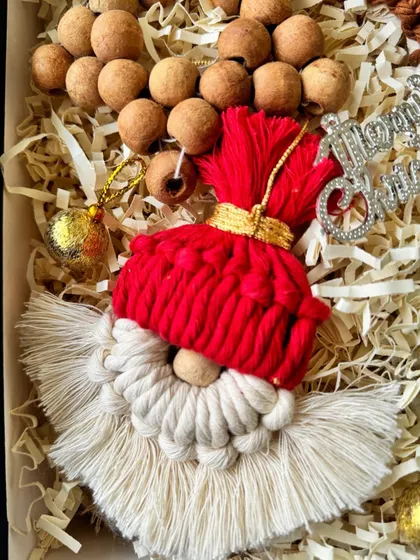 A close-up of the macrame Santa ornament, showing his fluffy beard and red hat.
