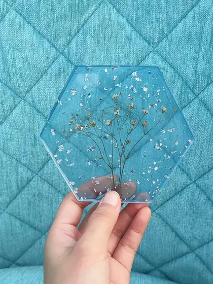 Another shot of the Gypsophila coaster against a different background. The transparency of the resin makes it look like the flower is floating in water.