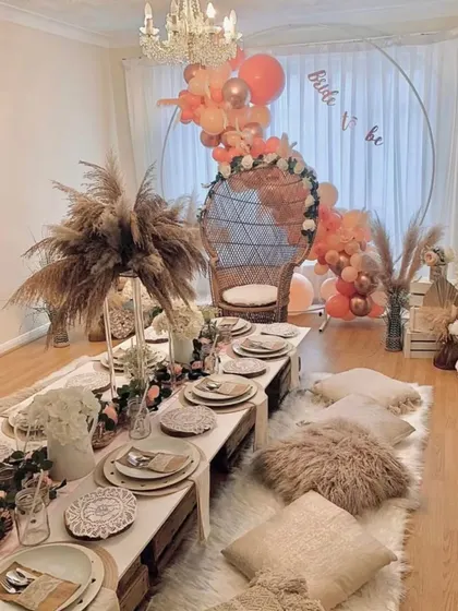 A look at our boho-chic bridal shower setup, designed to be effortlessly beautiful. We combine low wooden tables, plush floor cushions, and arrangements of pampas grass with a statement wicker chair for the bride-to-be, creating a picture-perfect celebration.