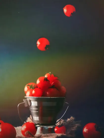 Cherry tomatoes seemingly floating out of a bucket. This playful levitation shot is a fun way to showcase fresh produce and grab attention.